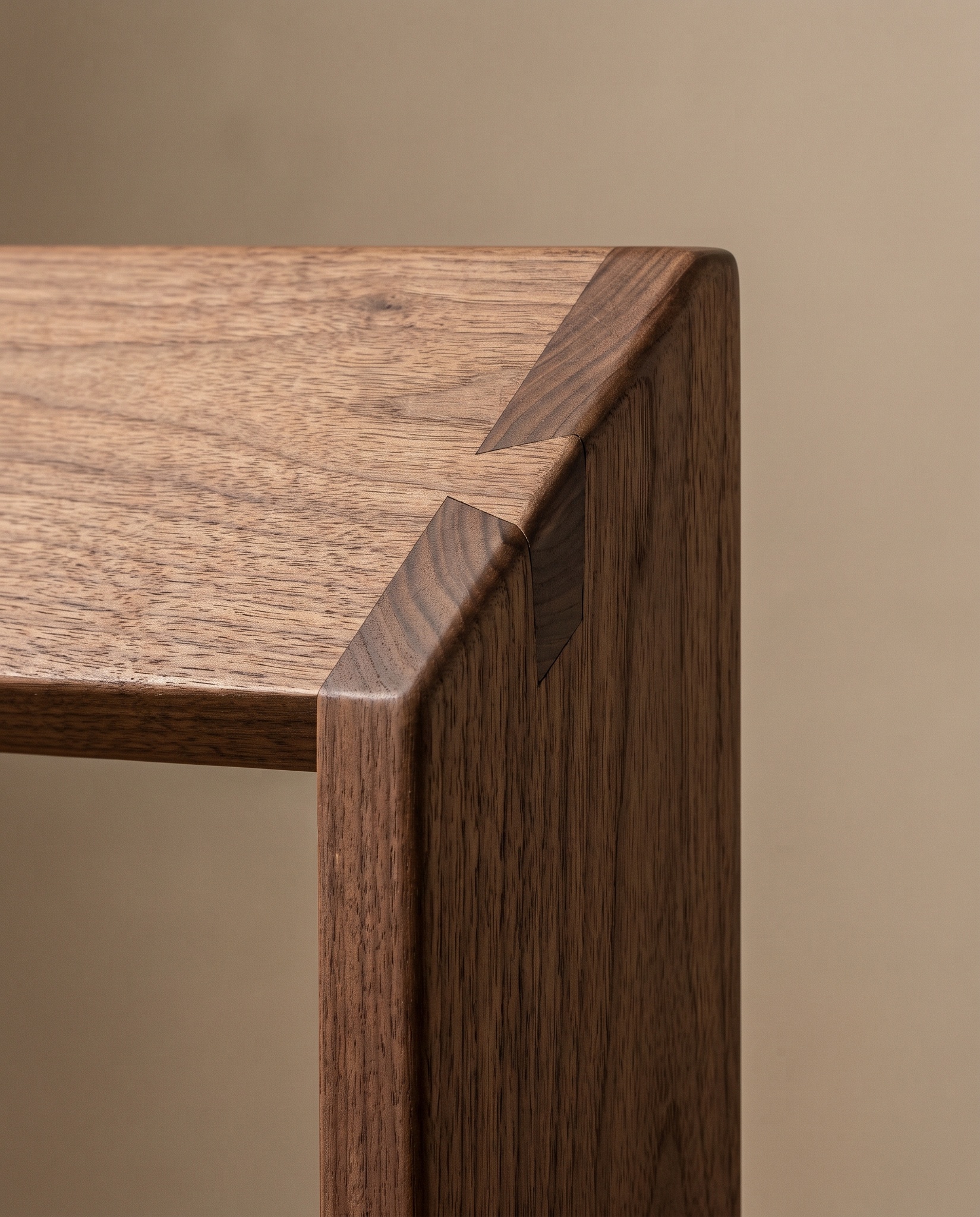 Close-up of a hand-cut dovetail joint in warm brown oak with visible grain against a beige background